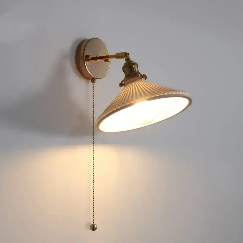 Brass-finished wall sconce with ribbed off-white ceramic canopy led shade and adjustable arm for bedroom decorbites ceramic canopy