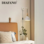 Vintage white ceramic wall lamp with wood accent and brass fittings mounted on wall by diafano for bedroom lighting