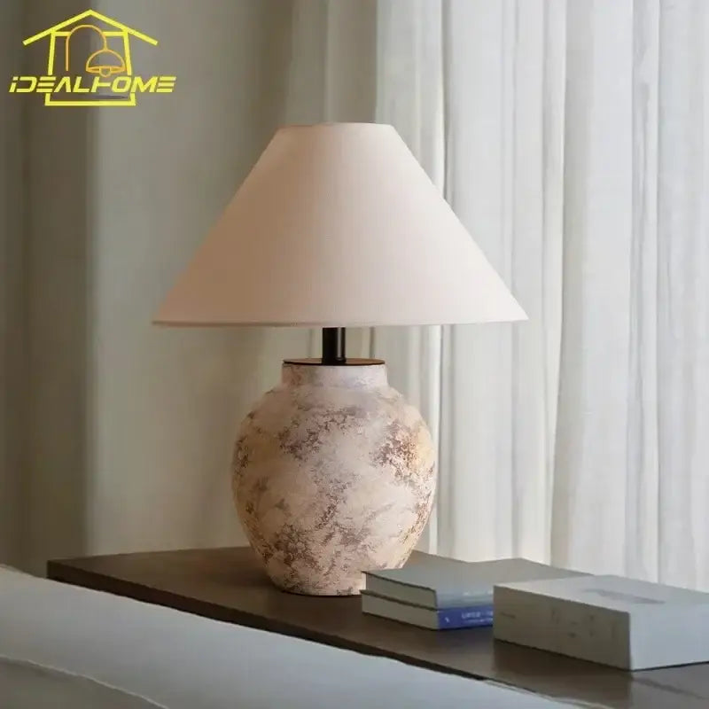 Cream-colored decorbites ceramic led table lamp with textured finish and beige fabric shade for bedroom decor