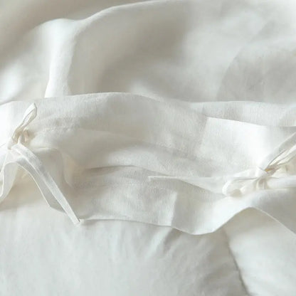 Soft off-white linen pillowcase with delicate folds and tie closures from vintage white and gray linen bedding set