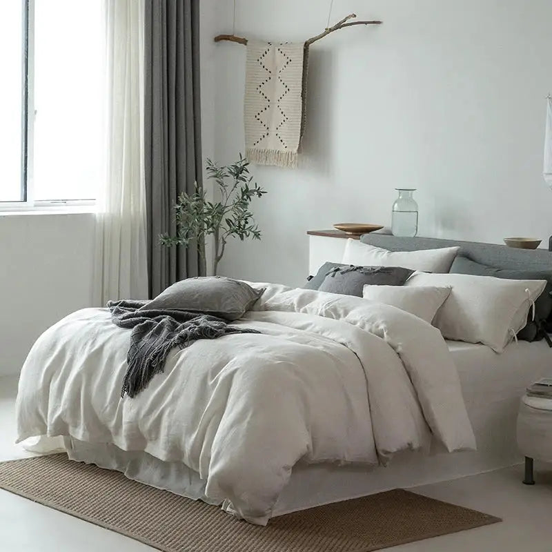 White linen bedding set with soft slightly wrinkled texture and matching pillowcases for bedroom use