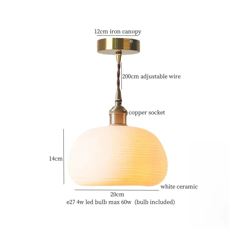 A warm white ceramic led pendant light with textured surface and brass fittings for kitchen dining room use