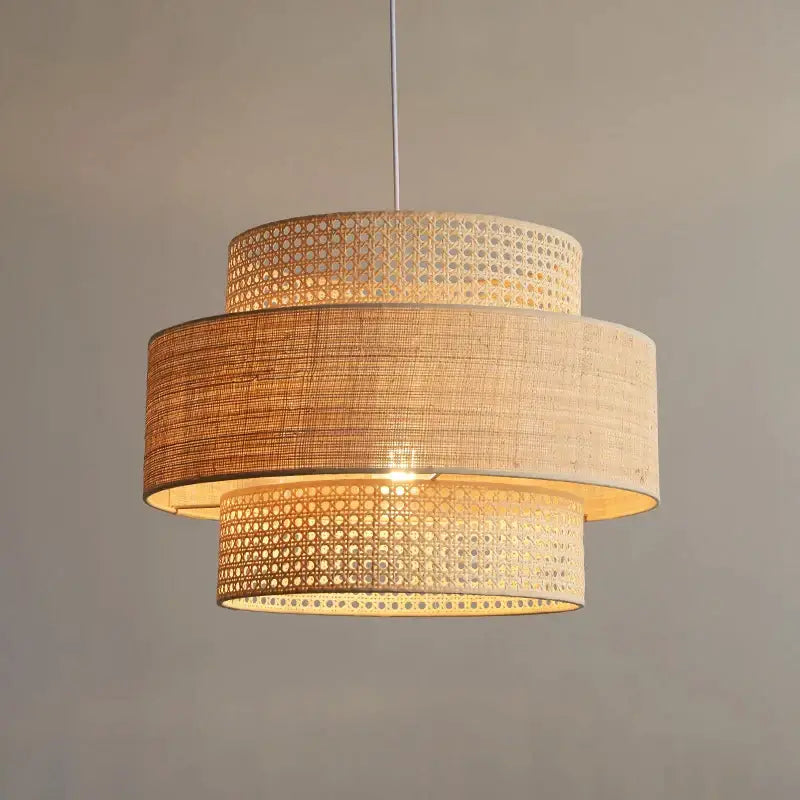 Beige and natural-toned bamboo wabi sabi pendant light with layered rattan and fabric shades for dining room