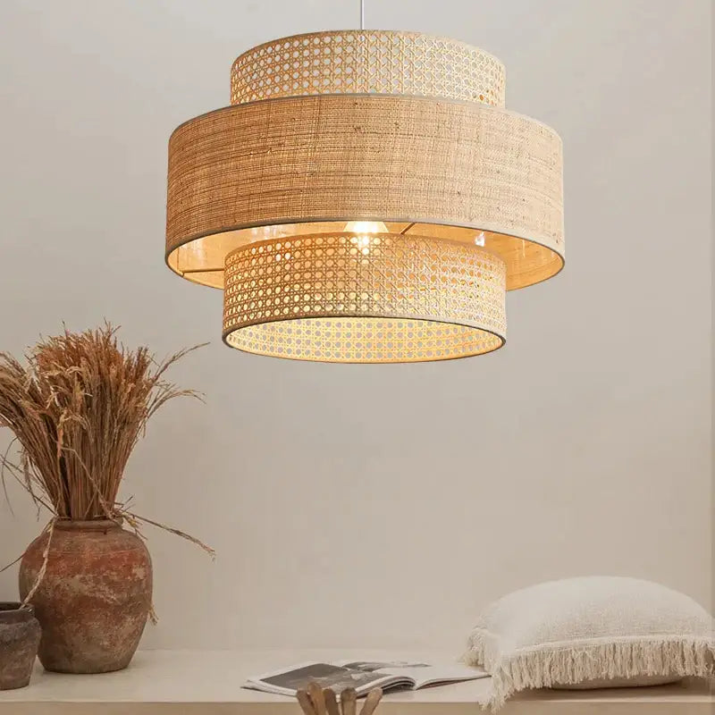 Beige woven rattan tiered wabi sabi pendant light with warm glowing interior ideal for dining room ambiance