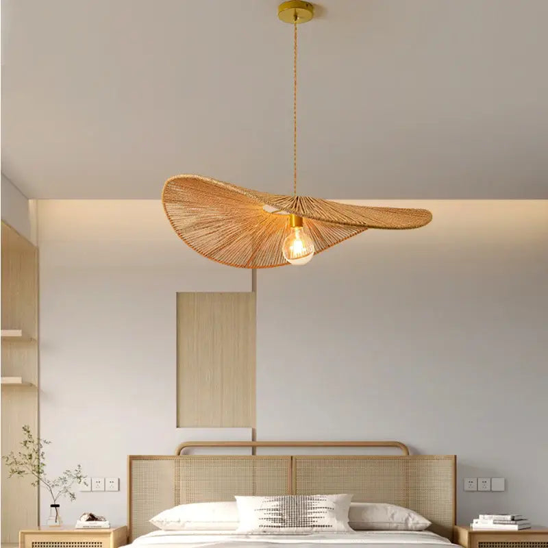 Golden-toned leaf-shaped pendant light with woven bamboo wabi sabi design and exposed bulb for dining room