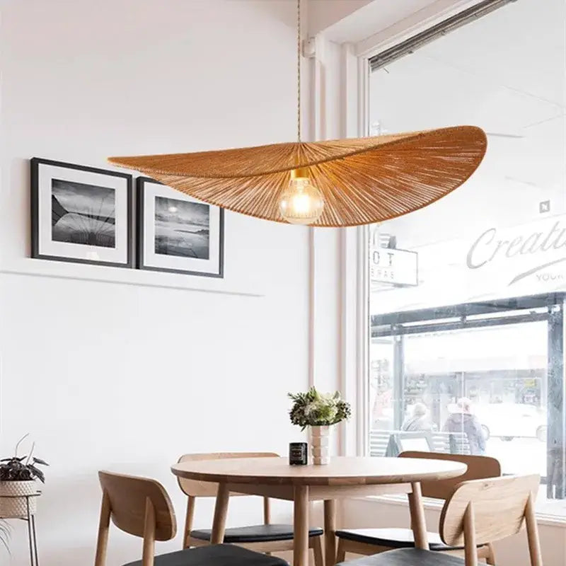 A warm-toned bamboo wabi sabi pendant light with radial fan design and exposed bulb for dining room lighting