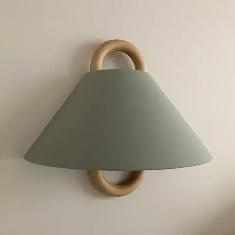 Wabi-sabi beech wood wall lamp with matte sage green fabric shade and natural wood rings for bedroom lighting
