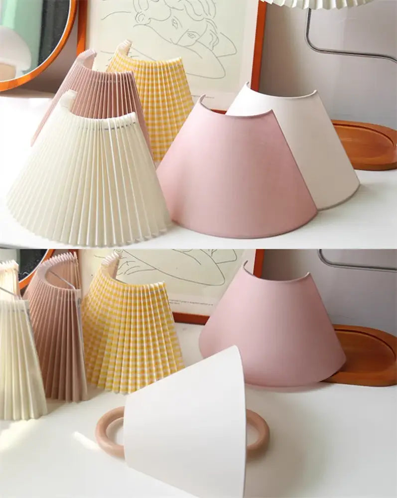 Pastel pink pleated lampshade with smooth matte finish on a wabi-sabi beech wood wall lamp for bedroom use