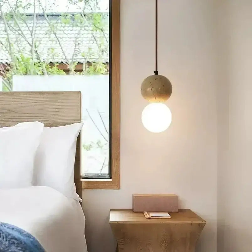 Minimalist pendant light with textured beige concrete sphere and smooth white glass bulb for decorbites elegant wabi sabi dining room decor