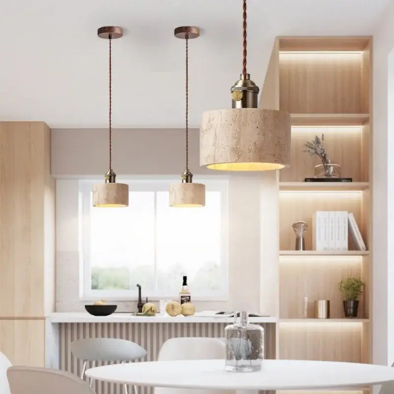 Three beige concrete pendant lights with textured shades and copper fixtures feature decorbites led yellow travertine accents