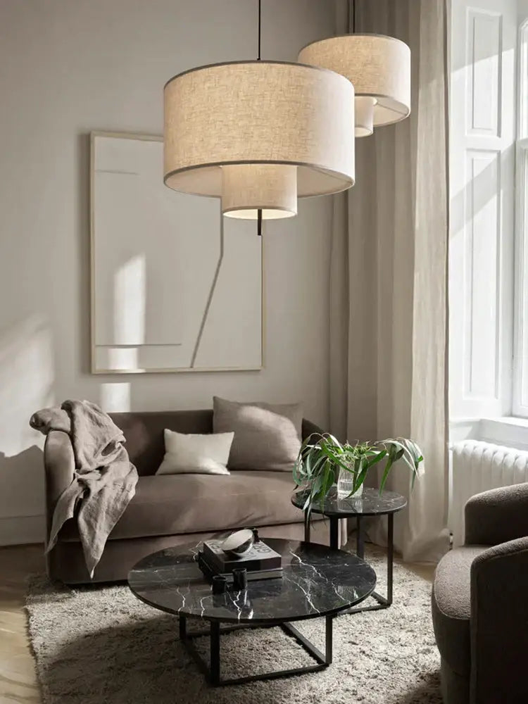 Beige linen cylindrical pendant lamps with tiered shades for dining room decor by decorbites bohemia wabi sabi