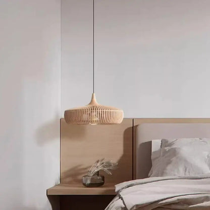 Wabi-sabi beige woven rattan pendant light with black cord as a living room light source over wooden bedside table