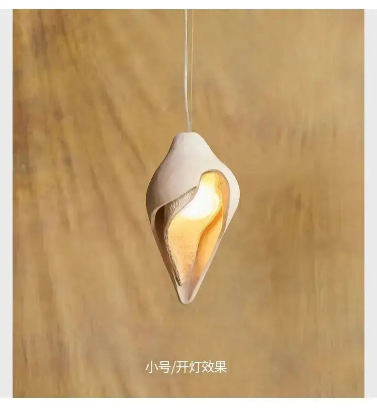 Wabi sabi cream gypsum conch pendant lamp with warm glowing seashell design in smooth white ceramic for living room decor