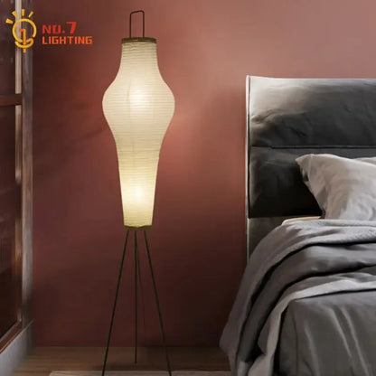 A tall cream paper tripod floor lamp with a black metal base ideal for living room art decor