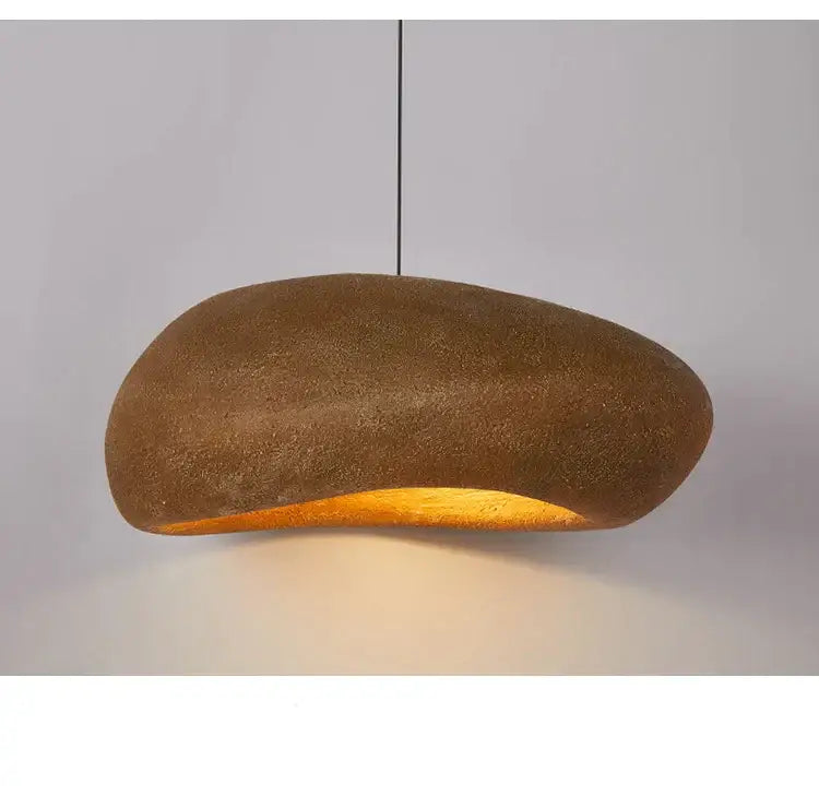A warm amber-glowing decorbites handmade polystyrene indoor pendant light with textured earthy-brown ceramic body