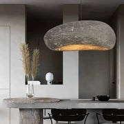 Wabi sabi gray decorbites handmade polystyrene indoor pendant light with textured stone finish and warm golden glow