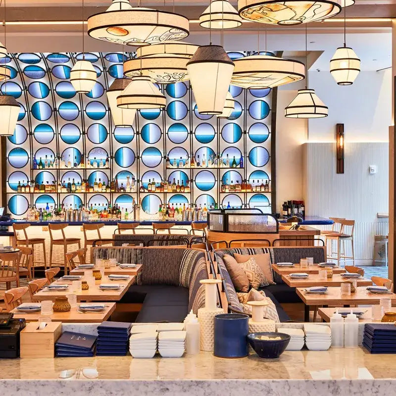 Wabi sabi illustrated fabric pendant lamp in blue complements decorbites colored wabi decor with circular glass wall behind bar