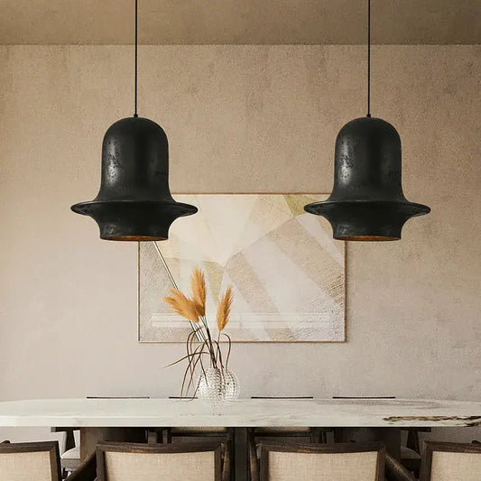 Two matte black wabi-sabi industrial chandelier pendant lights with rustic finish by decorbites black hang above dining table