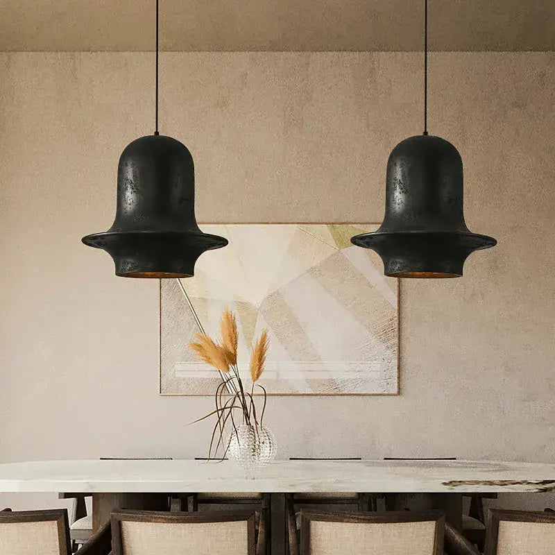 Two matte black wabi-sabi industrial chandelier pendant lights with rustic finish by decorbites black hang above dining table
