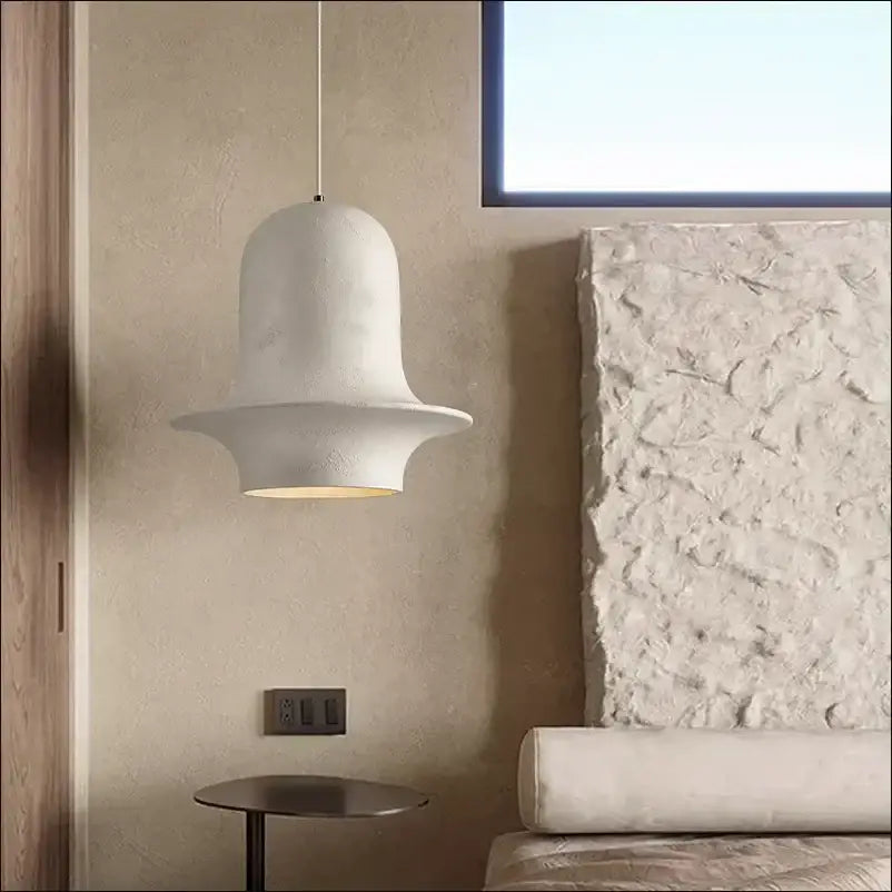 White ceramic bell-shaped pendant light with matte finish and soft glow from decorbites black wabi-sabi industrial chandelier