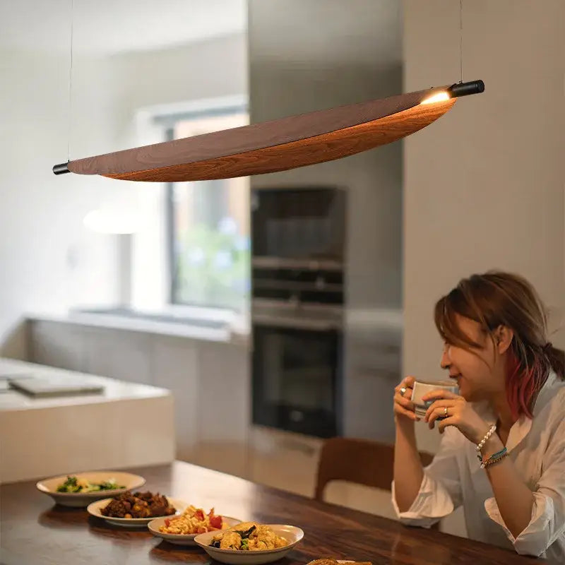Wabi sabi led wood pendant light with black metal ends and warm amber glow for dining room illumination