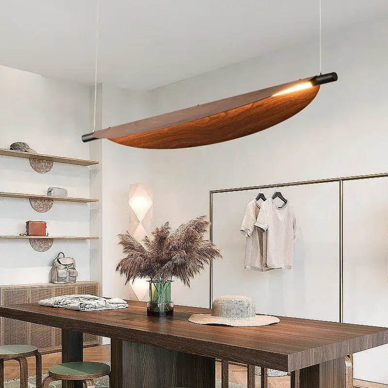 A sleek led wabi sabi wood pendant light with amber glow and black metal ends for dining room lighting
