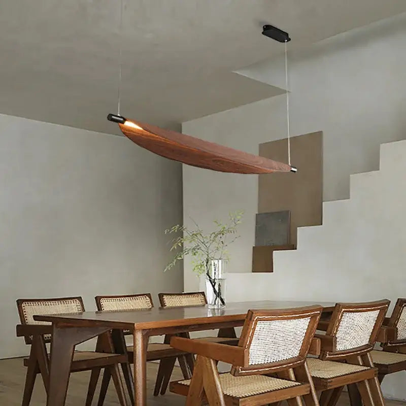 A sleek led wabi sabi wood pendant light with amber glow and black hardware for dining room illumination