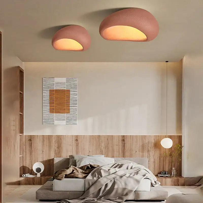 Two blush pink dome-shaped matte ceiling chandelier lights with warm glow for bedroom cream ceiling decor