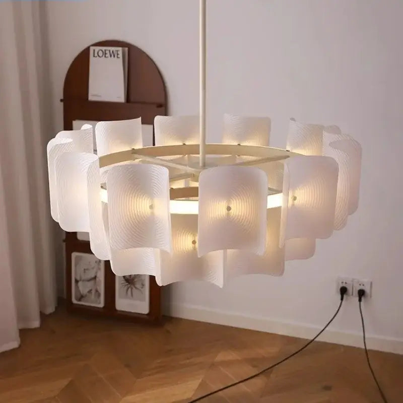 A modern off-white pendant light with a circular frame and wave-shaped glass panels in painted iron finish