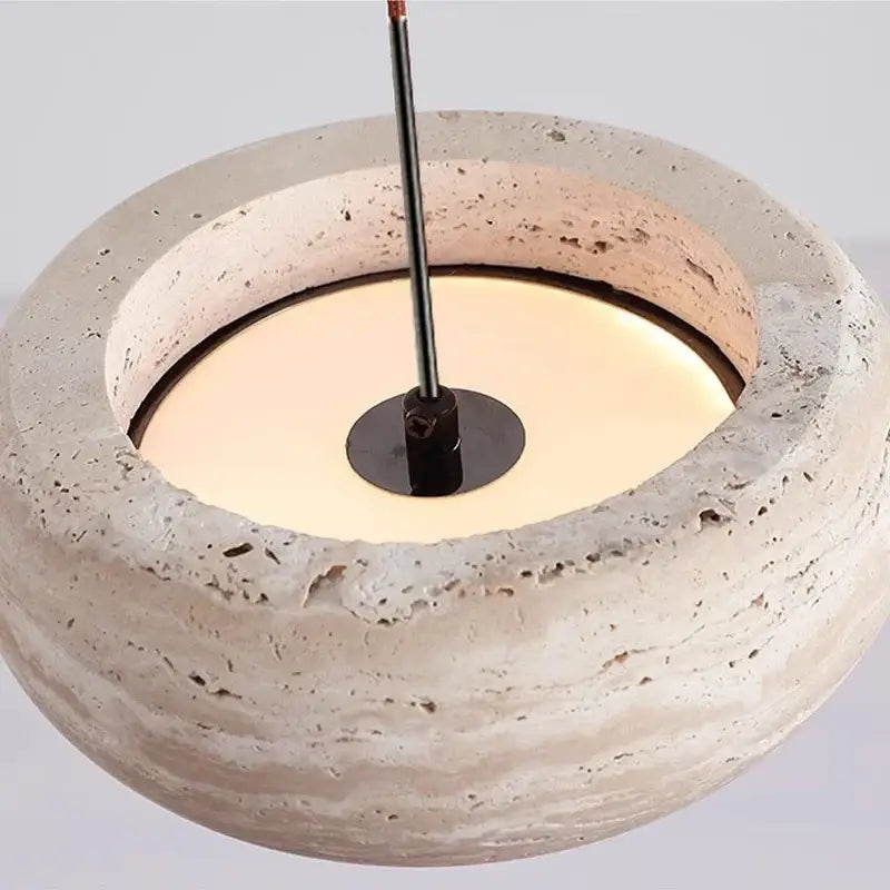 Wabi-sabi off-white stone pendant light with rounded beige textured concrete and central black metal fixture for dining room