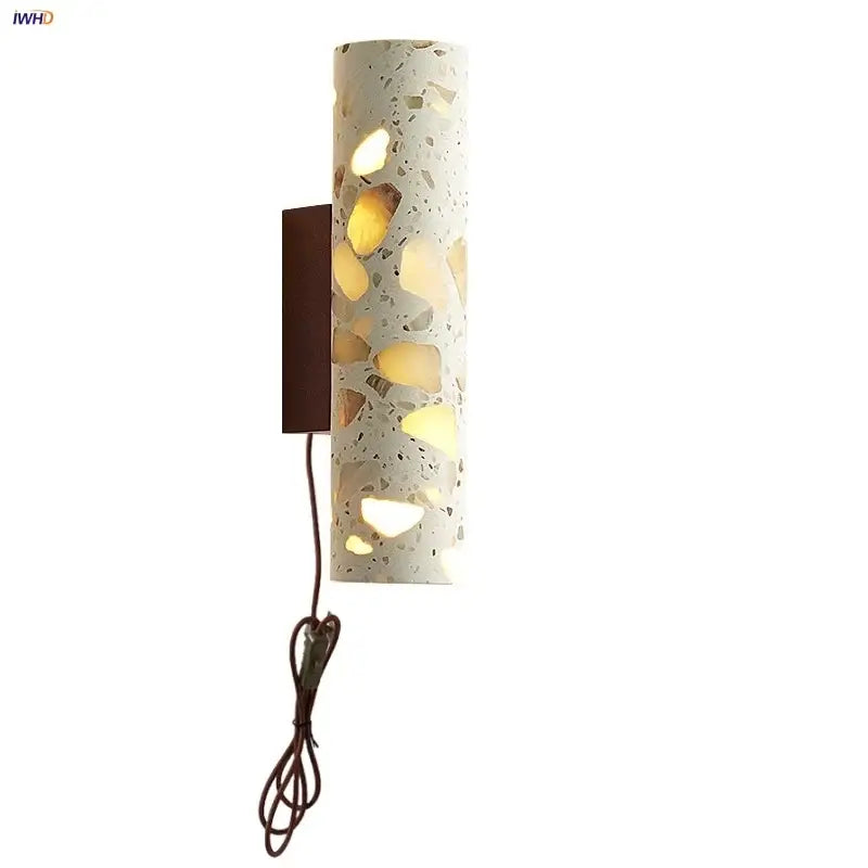 Cylindrical terrazzo led wall light with amber and beige stone fragments on dark brown metal bracket for bedroom decorbites wall lights