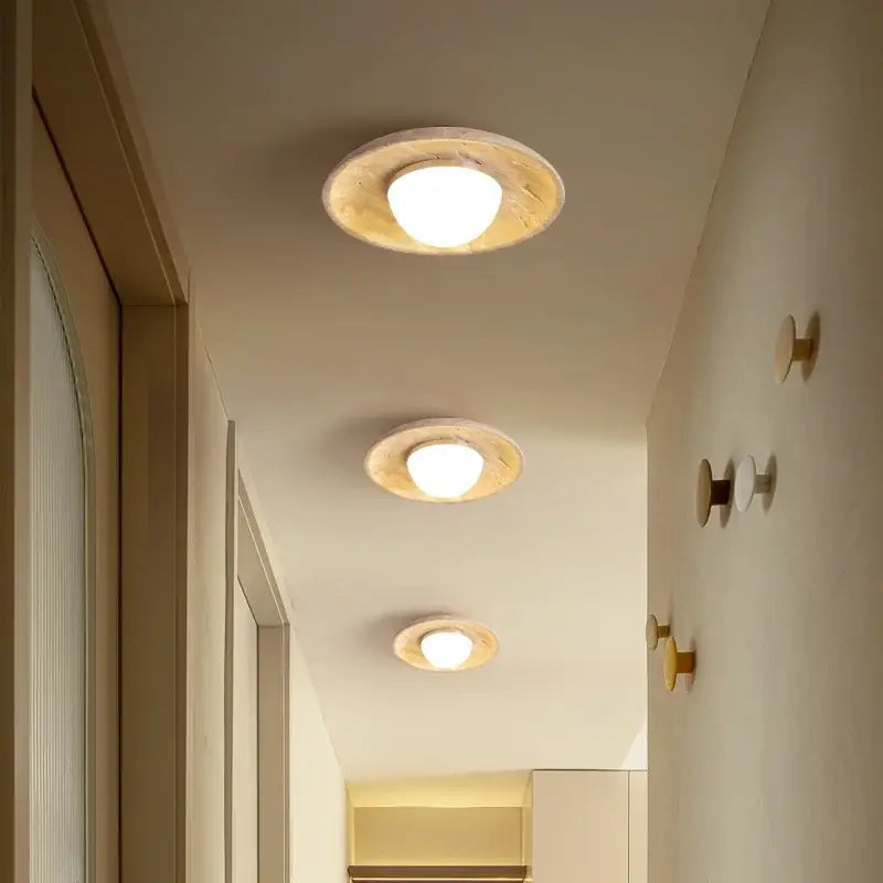 Three circular recessed warm acrylic led ceiling lights encased in rustic light wood frame wabi sabi travertine wood lamp
