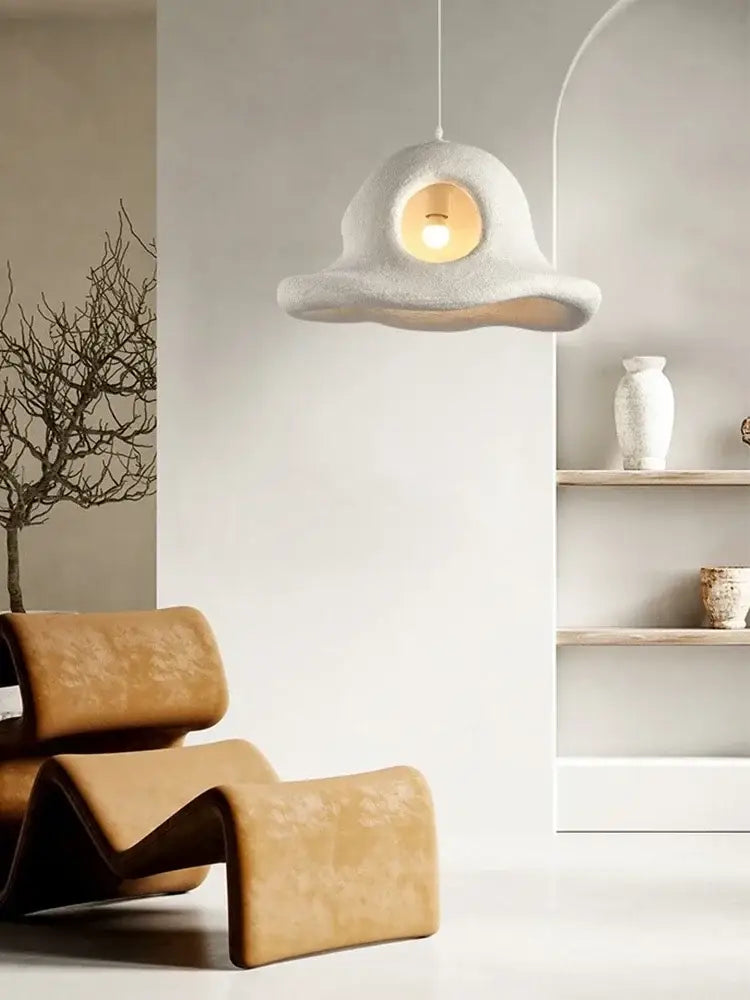 A sculptural off-white concrete pendant light with a circular cutout revealing warm glow decorbites island led chandelier