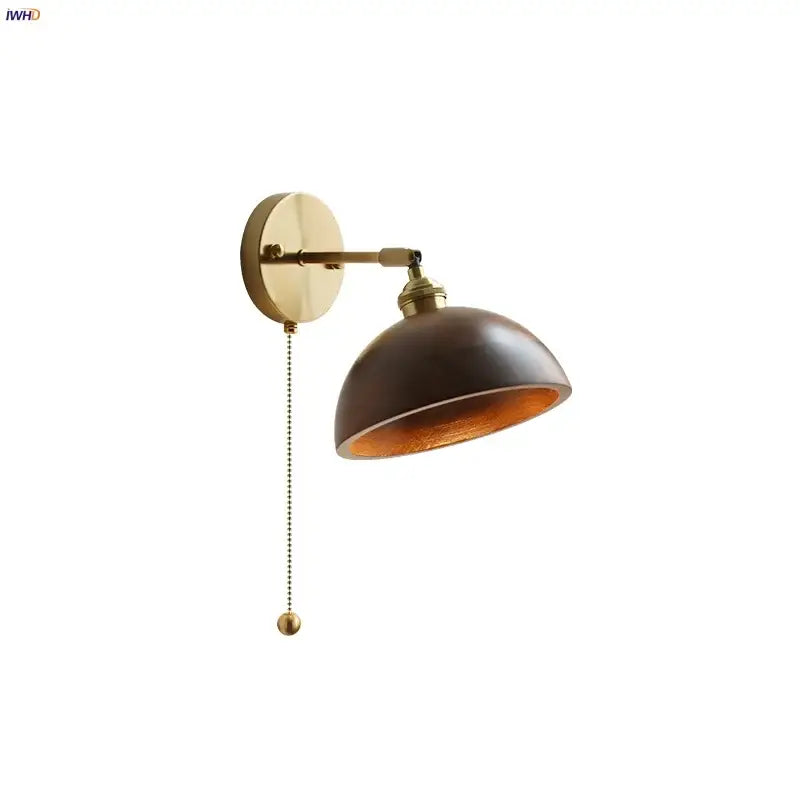 Walnut and brass wall sconce with pull chain switch featuring brass finish, dark brown domed shade, and amber interior