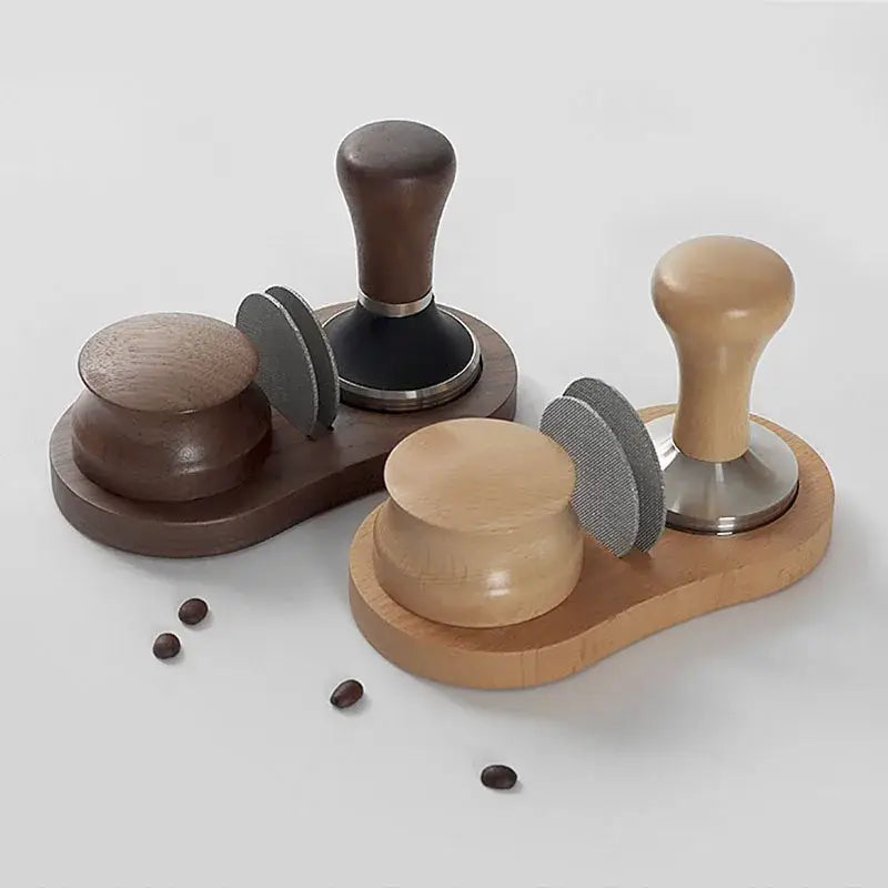 Set of two walnut and oak espresso tampers with gray silicone sleeves on a matching wooden tamping station tray by decorbites