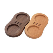 Two wooden tamping stations in dark walnut and light oak with circular indentations and grooves for espresso tampers