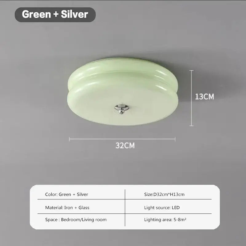 A sleek round ceiling light with translucent green double layer glass led shade and silver iron fixture for bedroom
