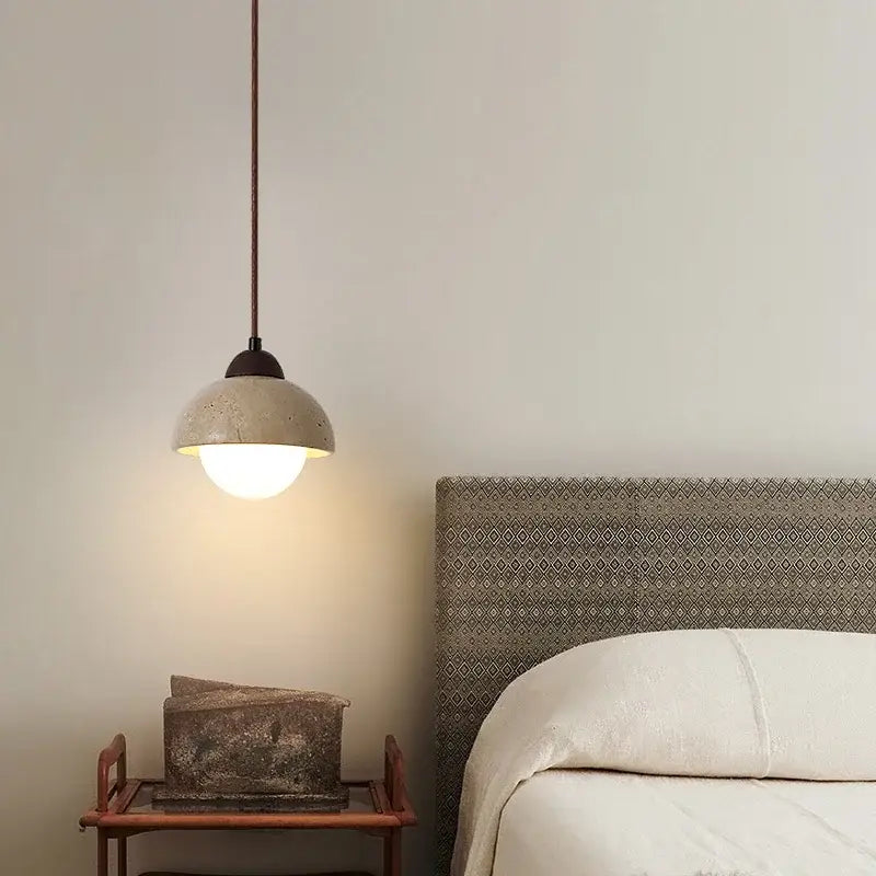 A warm-toned cave stone pendant light with textured concrete finish and dark metal hardware for dining room decorbites cave stone