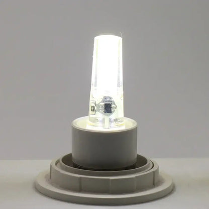 A sleek warm yellow glass decorbites g4 cob led bulb with clear glass housing and white plastic base for living room light