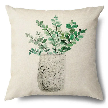 Beige linen pillow case with watercolor green leaves decorative design on speckled gray vase for living room use