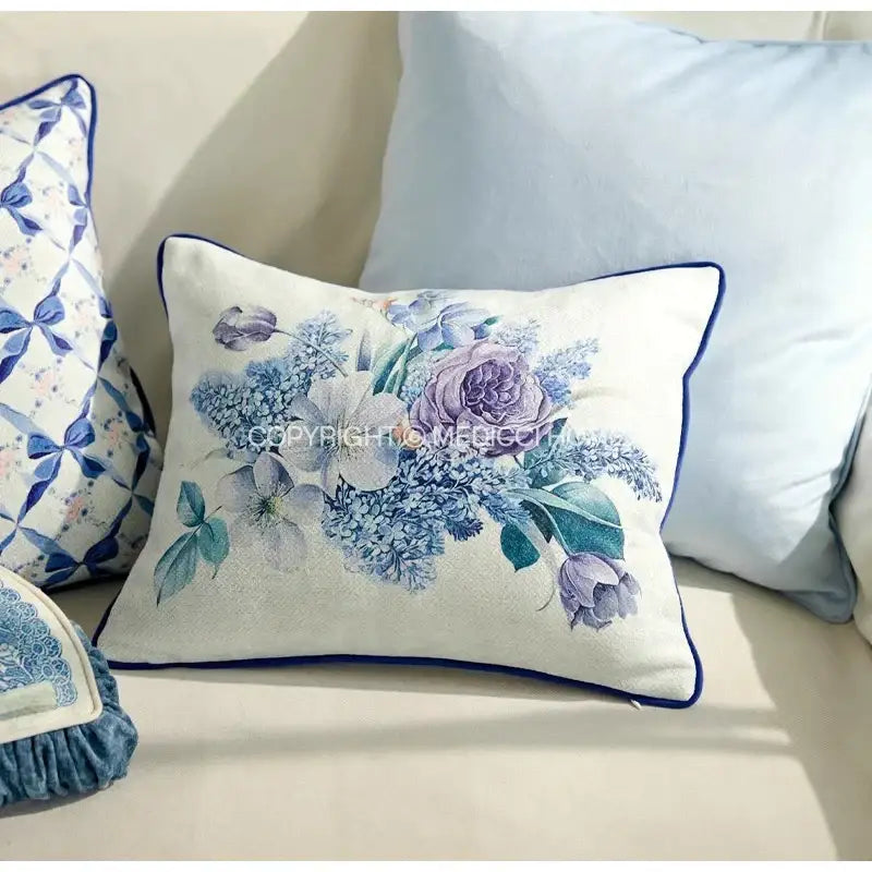 A rectangular cushion cover with decorbites iris flowers and butterfly in purple on cream fabric with navy piping