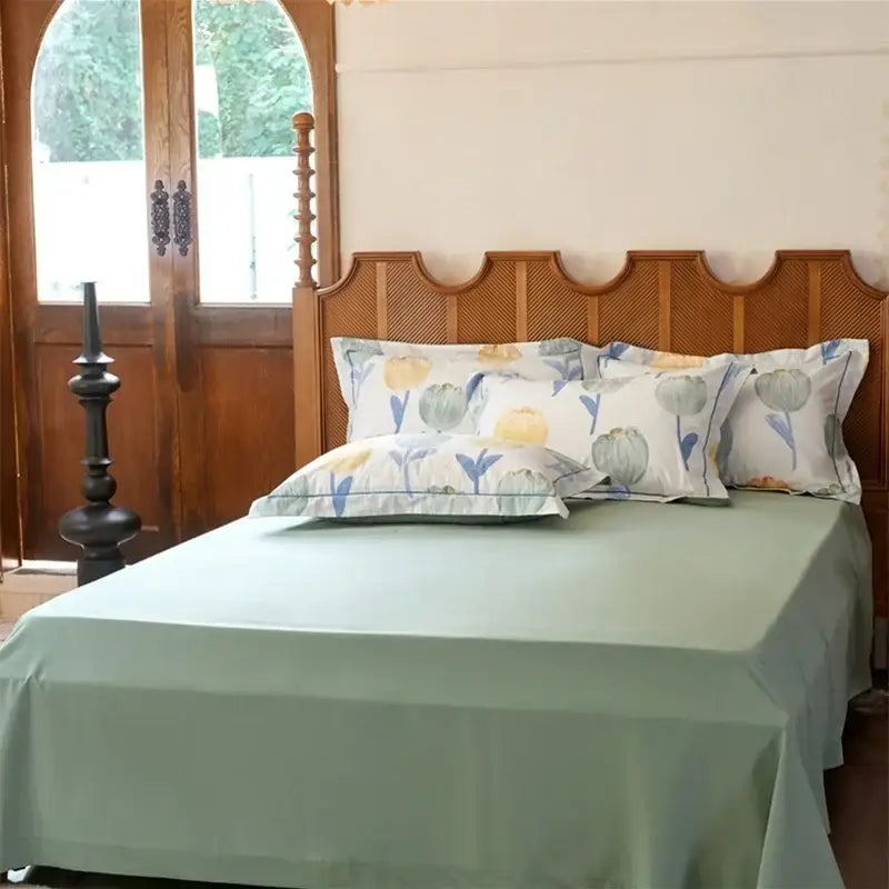 Light green satin bedspread with matching pillowcases featuring a soft watercolor floral pattern in a decorbites cotton bedding set