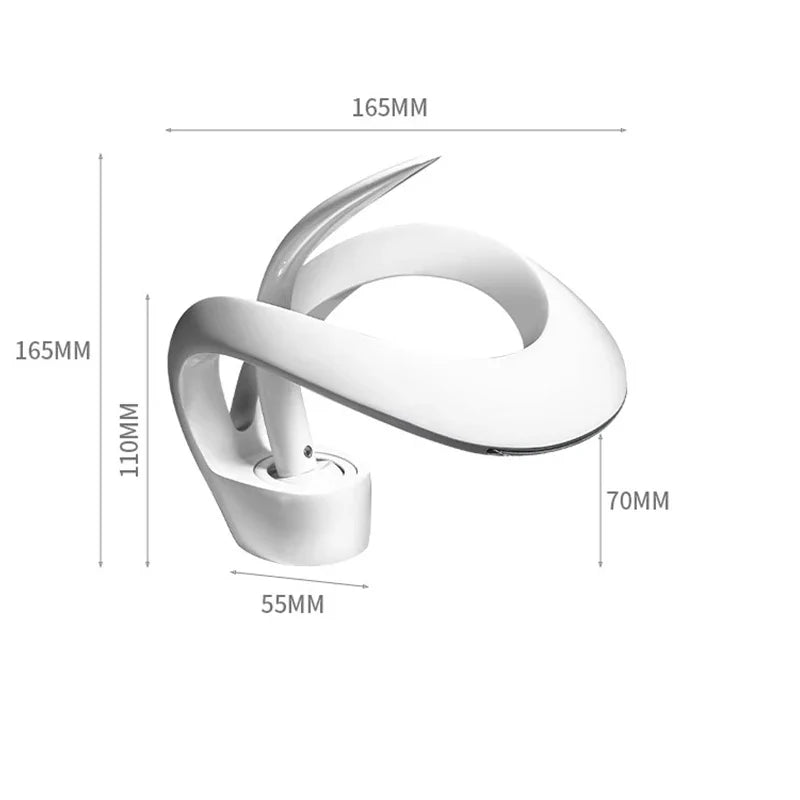 Modern white ceramic desk lamp with sleek curves shown next to single hole deck mounted waterfall bathroom basin faucet