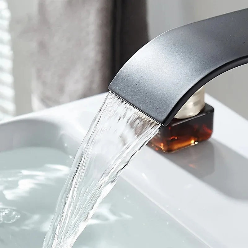 Modern matte black stainless steel wash basin faucet with sleek curved design and waterfall spout for bathroom use