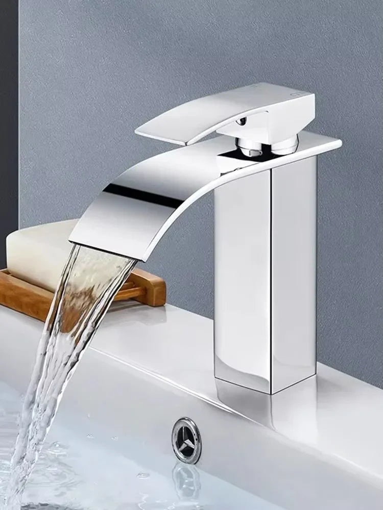 Modern chrome-finished stainless steel waterfall wash basin faucet with sleek angular design and curved spout for bathroom use