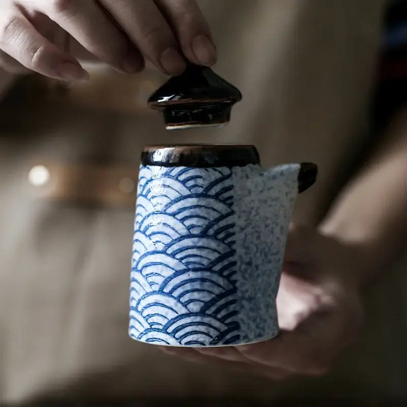 A ceramic tea pot with blue and white wave pattern and dark brown lid from decorbites blue ceramics seasoning set