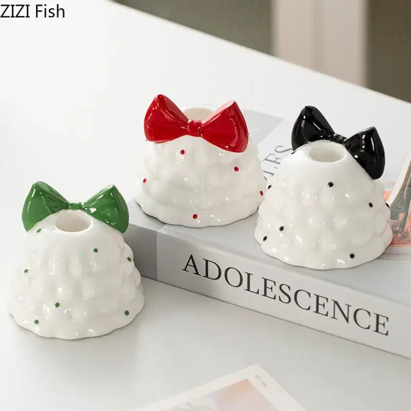 Three ceramic candle holders shaped like dresses with bows in green red and black decorbites bowknot tree design