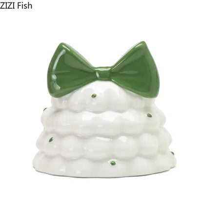 Whimsical white ceramic candle holder shaped like a bowknot tree with a glossy green bow and decorative green dots decorbites bowknot tree