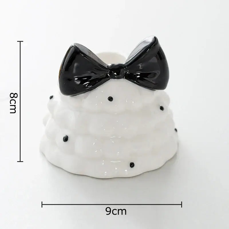 White ceramic candle holder shaped like tiered cake with black bowknot tree accents decorbites bowknot tree decor