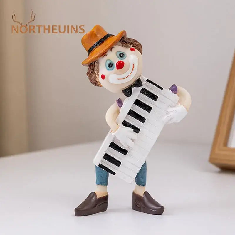 A whimsical decorbites clown resin art statue featuring an orange hat blue pants and a white accordion for living room decor